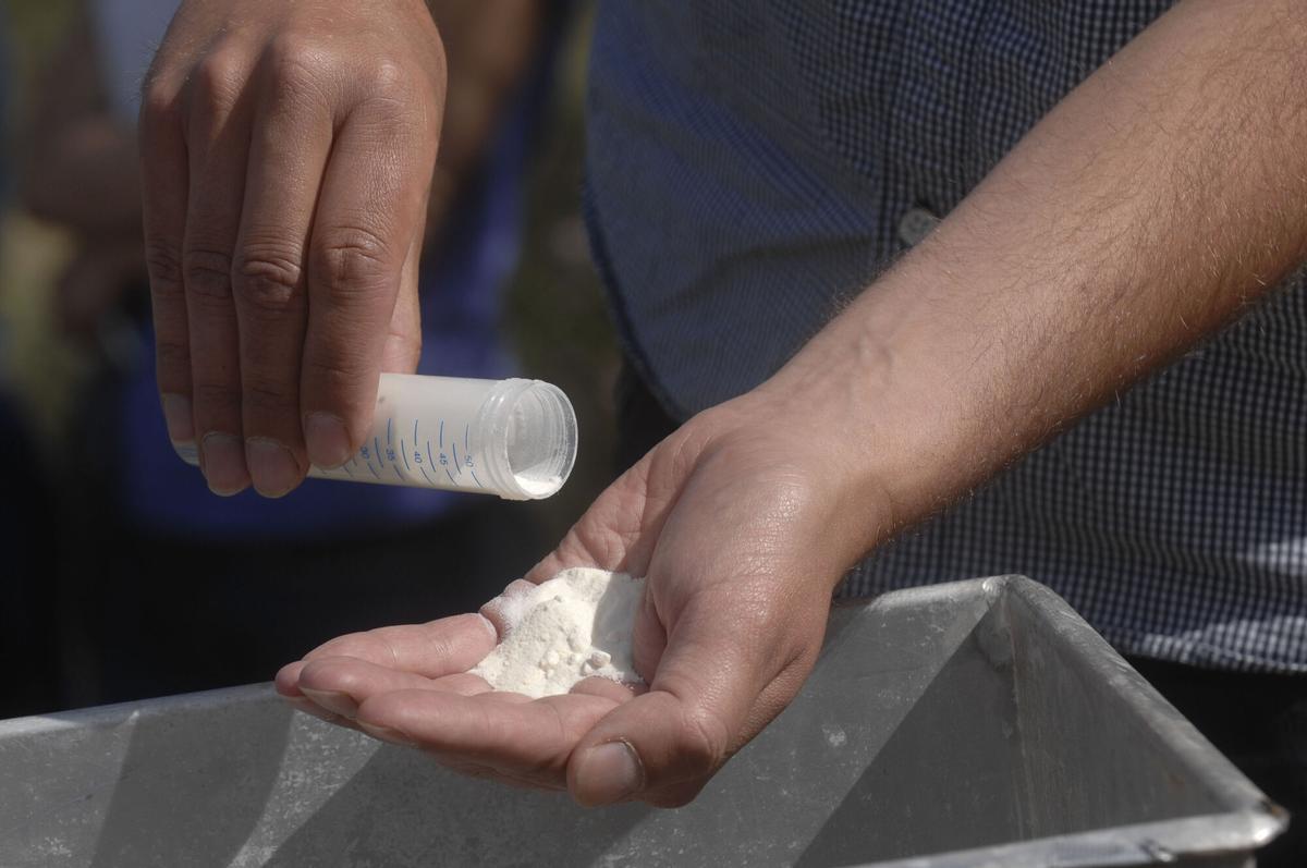 Un técnico vierte el contenido de una biobala en un depósito distribuidor como tratamiento contra el mejillón cebra.