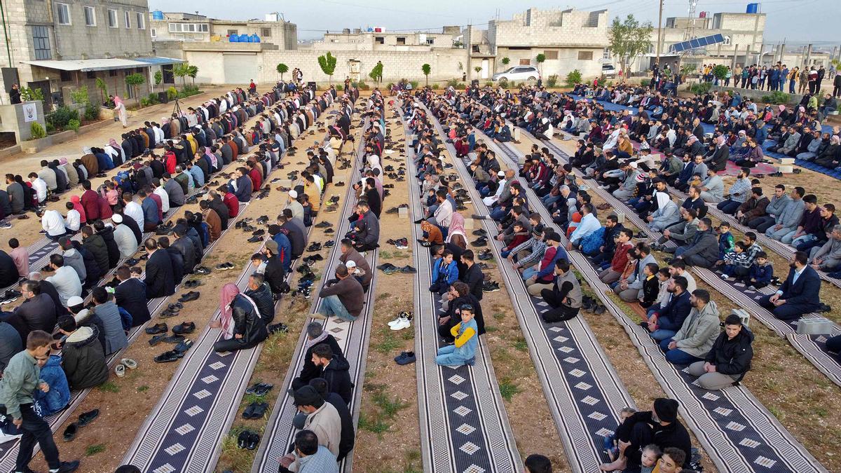 Fieles rezando el primer día de Eid al-Fitr, que marca el final del sagrado mes de ayuno del Ramadán, en un campamento para desplazados sirios cerca de la ciudad de al-Bab, controlada por Turquía, de la provincia de Alepo