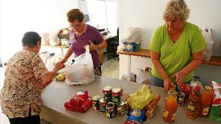 Voluntàries de Càritas preparant bosses amb aliments per als més necessitats a Llagostera.