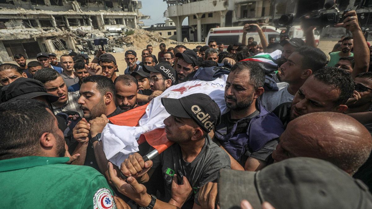 Varios hombres portan el cadáver de Anas Al Sharif, este lunes en Gaza.