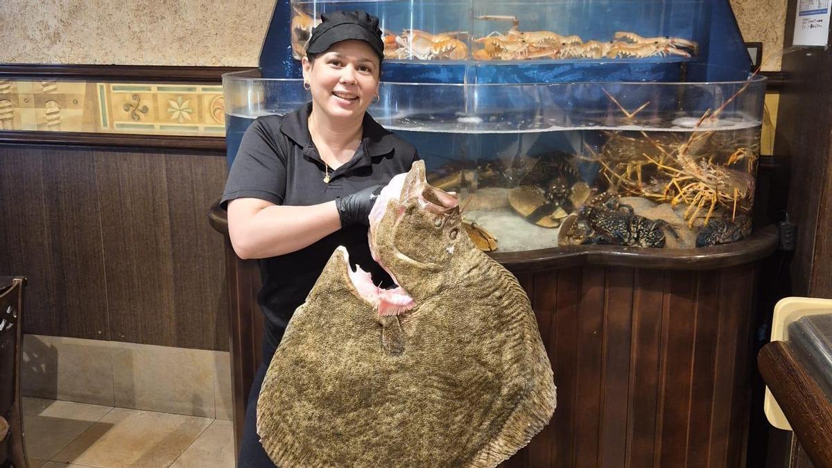 Laura, ayudante de cocina en "Ataulfo" con el rodaballo de 11 kilos.