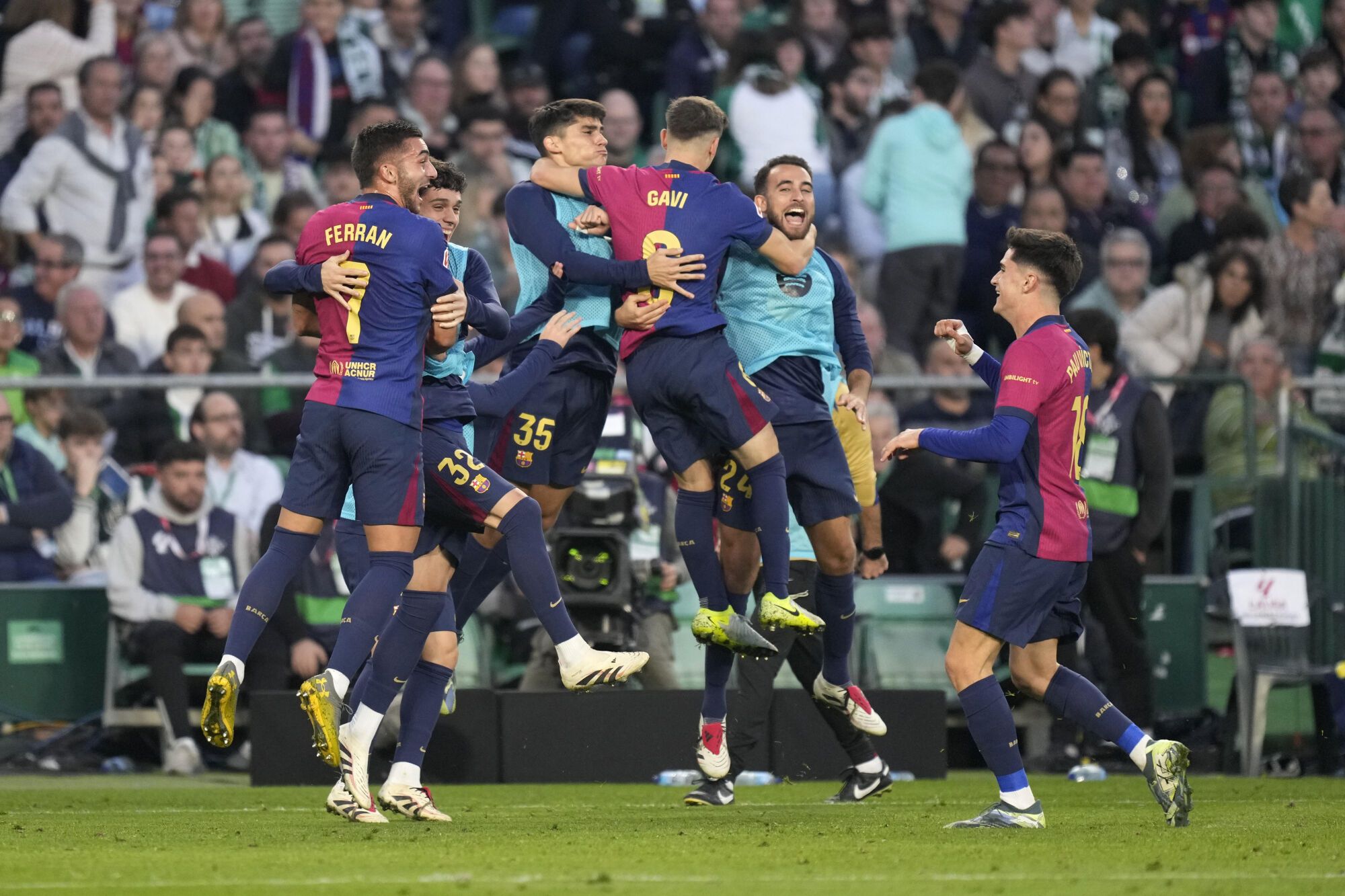 Barcelona players celebrate after Barcelona's Ferran Torres scored his side's second goal during a Spanish La Liga soccer match between Betis and Barcelona at the Benito Villamarin stadium in Seville, Spain, Saturday, Dec. 7, 2024. (AP Photo/Jose Breton). EDITORIAL USE ONLY/ONLY ITALY AND SPAIN