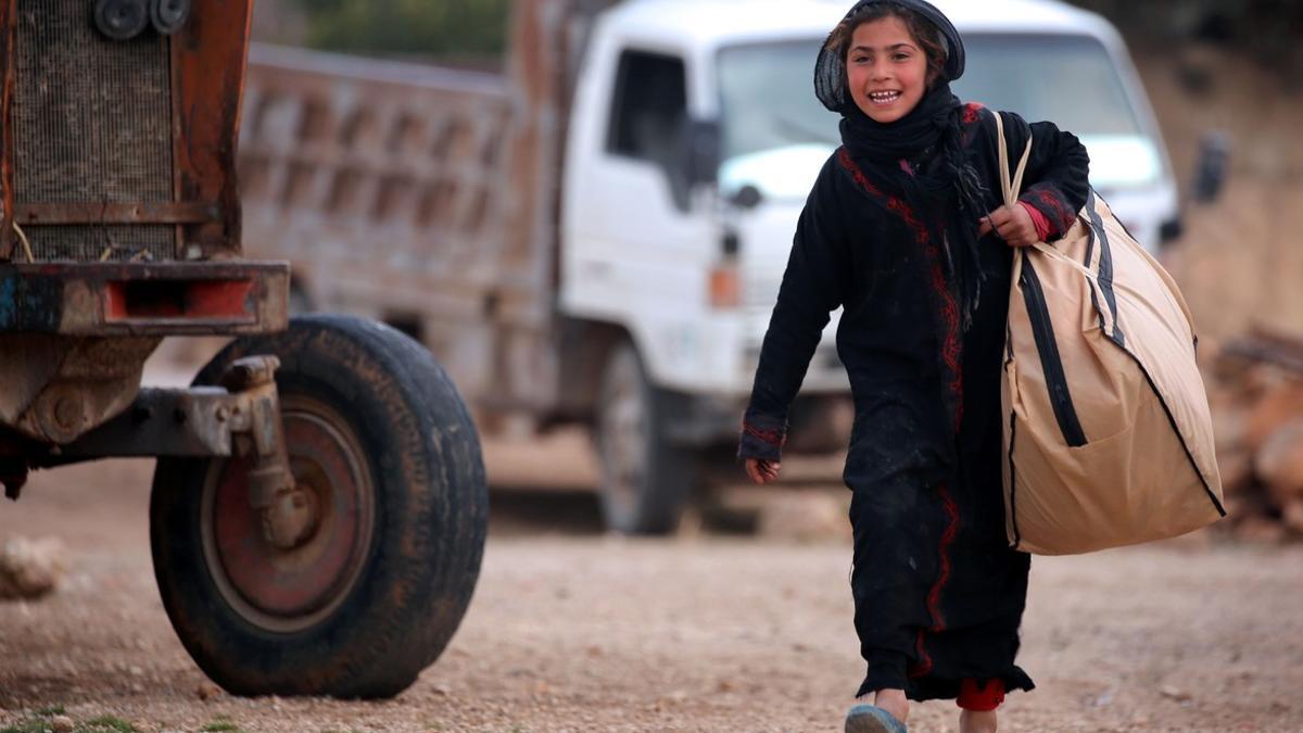 Una niña siria carga una bolsa en Jarufiya, a 18 kilómetros de Manbij.