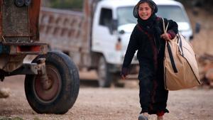 Una niña siria carga una bolsa en Jarufiya, a 18 kilómetros de Manbij.