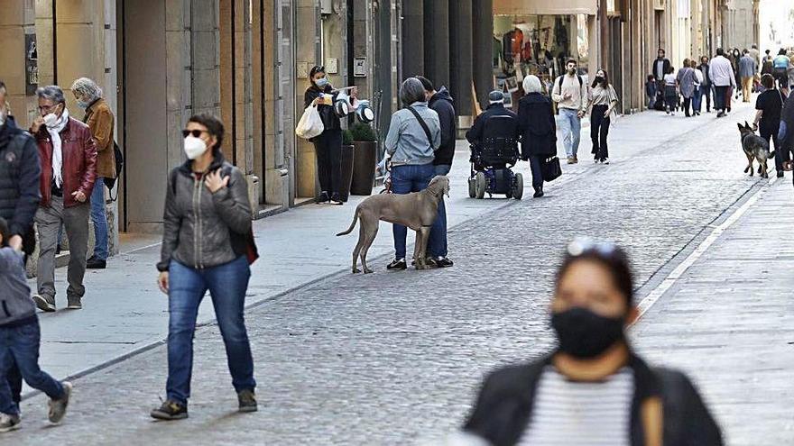 Gent passejant pel centre de Girona durant el confinament perimetral.