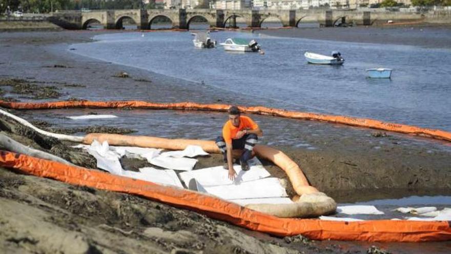 Barreras anticontaminación instaladas en la ría tras el vertido de queroseno. / eduardo vicente