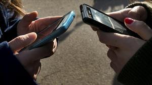 Unas jóvenes establecen contactos a través del móvil.