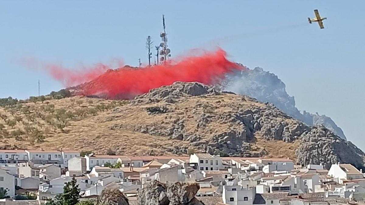 Una avioneta del Infoca lanza líquido sobre las llamas del incendio de Luque, este lunes.