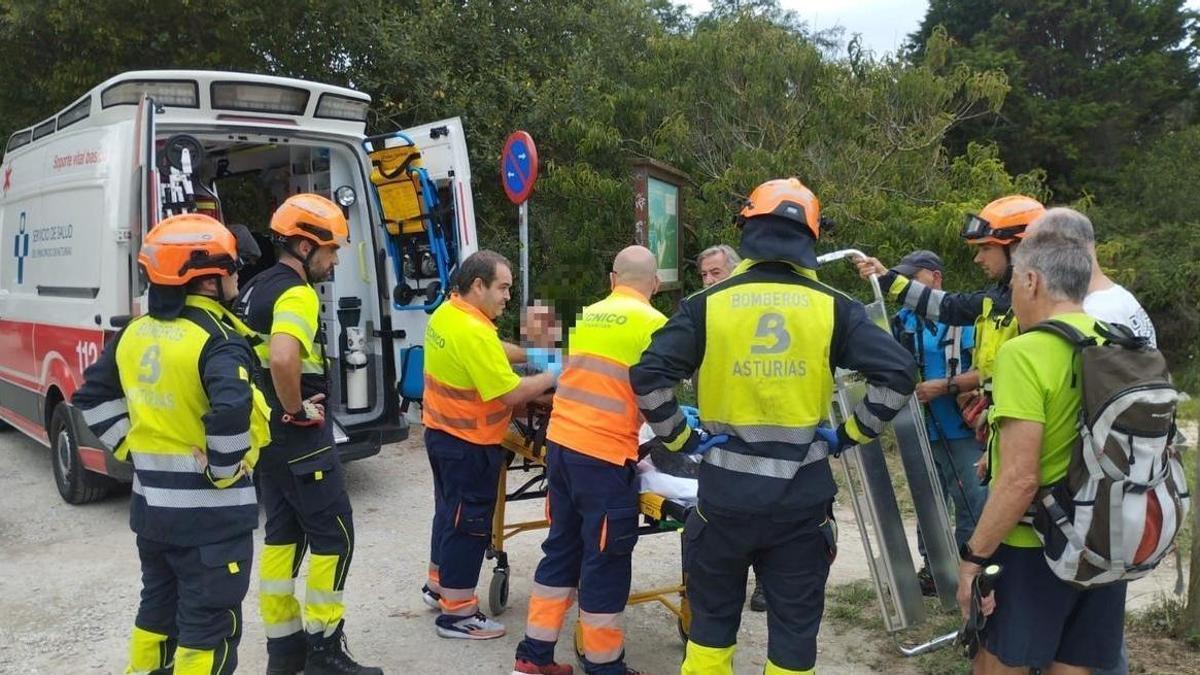 Bomberos y sanitarios con el un afectado en una camilla.