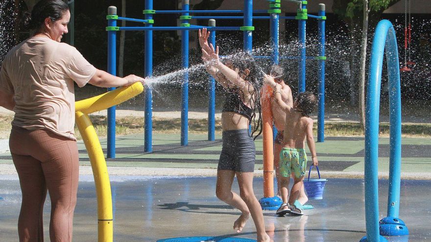 Los niños disfrutan en el parque infantil con juegos de agua de la calle Concello.