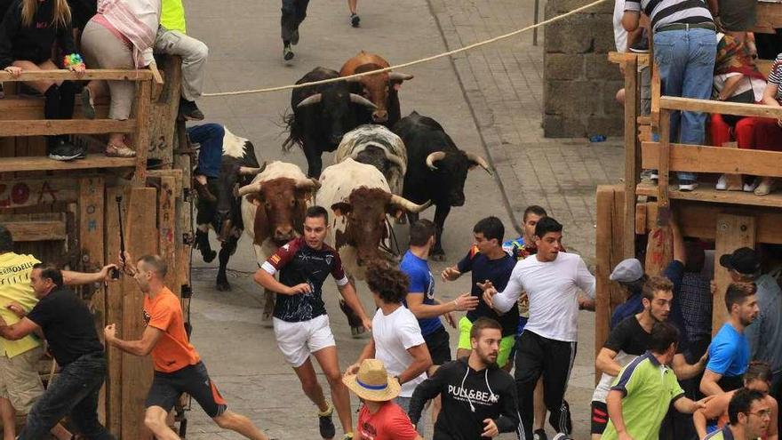 Los aficionados buscan refugio a la llegada de los novillos a la Plaza Mayor.