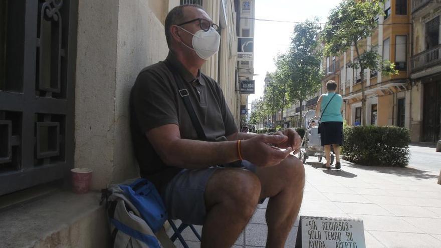 Un parado de larga duración pide ayuda en la calle.