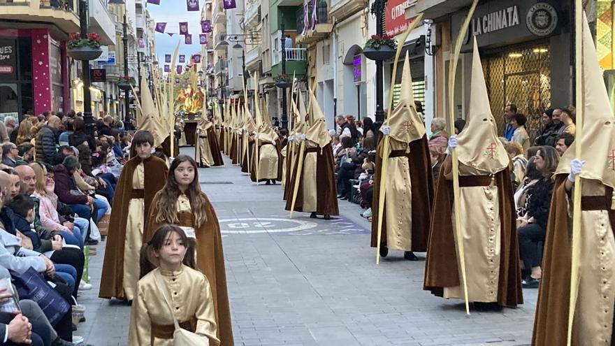 La primera de las hermandades que desfiló por la calle Sant Francesc de Borja llena de público, con la imagen al fondo. | T.Á.C.