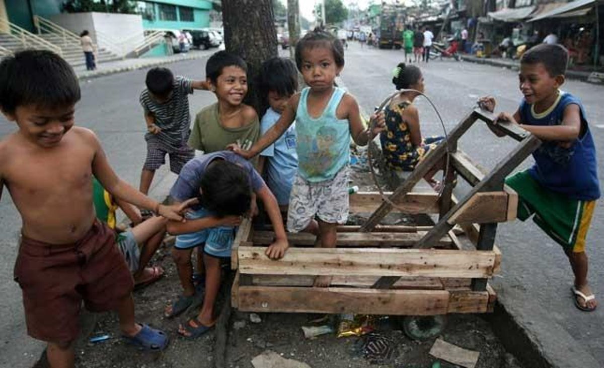 Nens juguen en un carrer d’un barri de barraques a Quezon City, a l’est de Manila (Filipines).