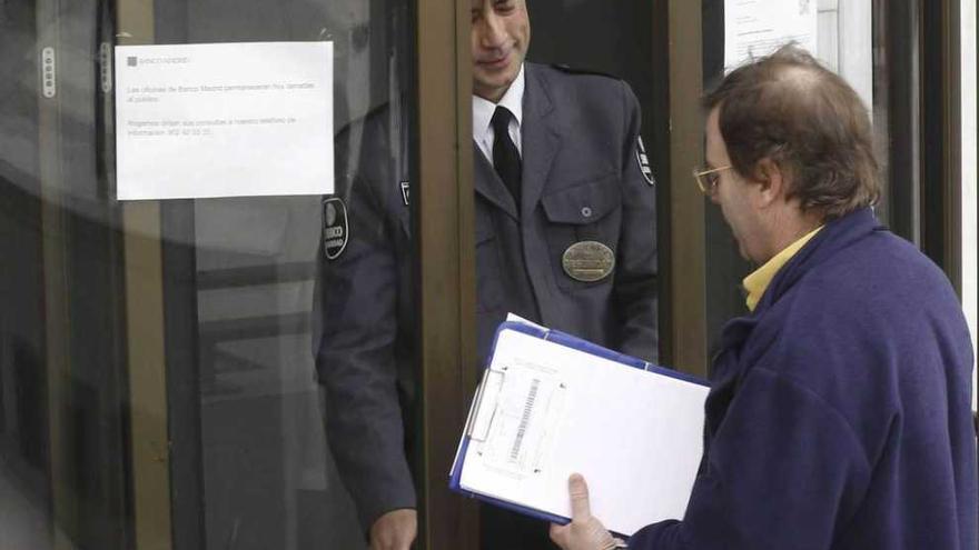 Un cliente intenta acceder a una oficina cerrada de Banco Madrid.