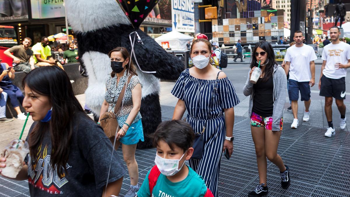 Varias personas caminan en Times Square.