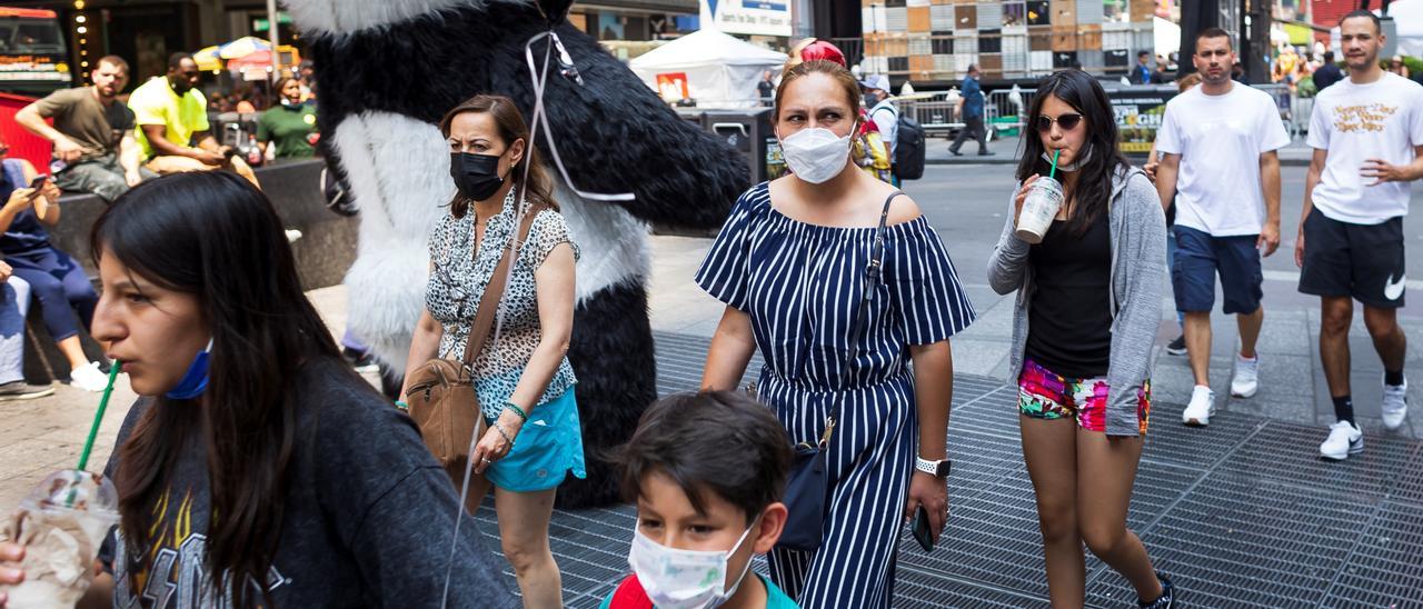 Varias personas caminan en Times Square.