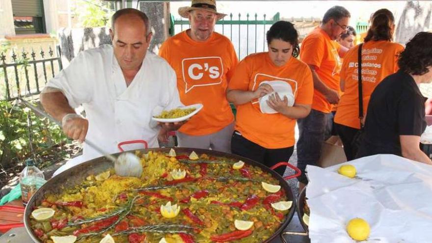 Apolinar Limia, el maestro paellero, sirviendo una ración.