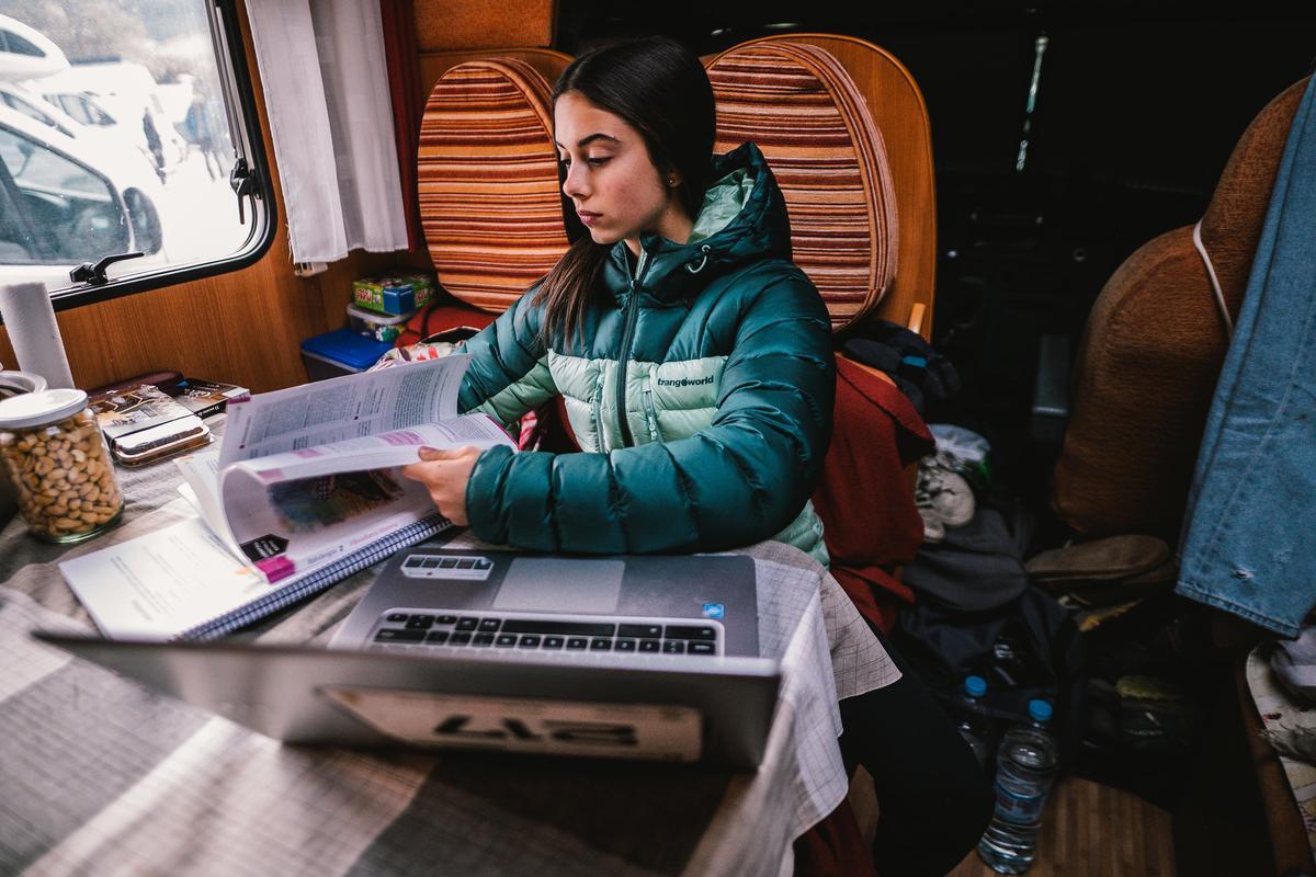 No es fácil conciliar los estudios durante los viajes de escalada. Ainhize dedica un rato a los libros en la autocaravana familiar