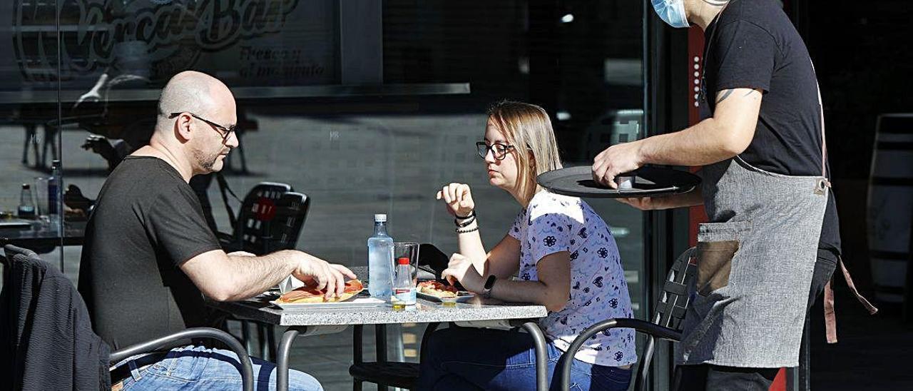 Un camarero sirve mesas en la cafetería del Mercat del Prado, en Gandia.