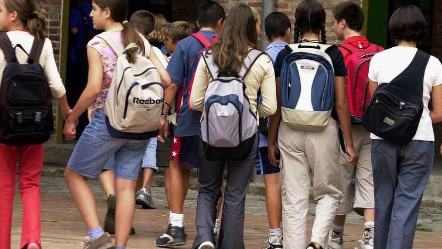 Un grupo de alumnos con mochilas en la entrada de un instituto.