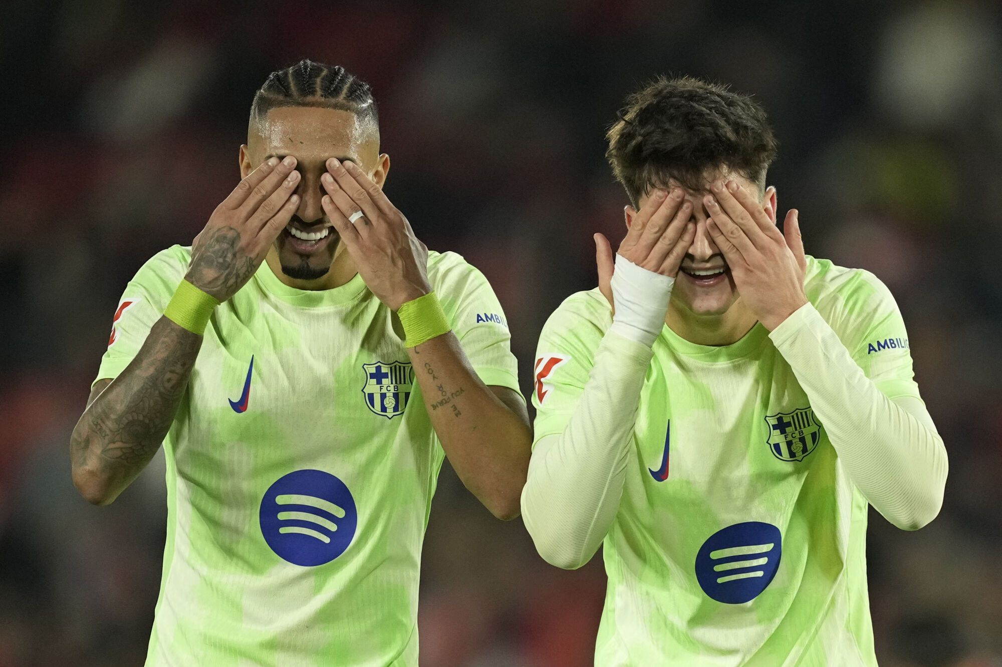 Barcelona's Pau Victor, right, celebrates with Raphinha after scoring his side's fifth goal during a Spanish La Liga soccer match between Mallorca and Barcelona at the Son Moix stadium in Palma de Mallorca, Spain, Tuesday, Dec. 3, 2024. (AP Photo/Jose Breton)