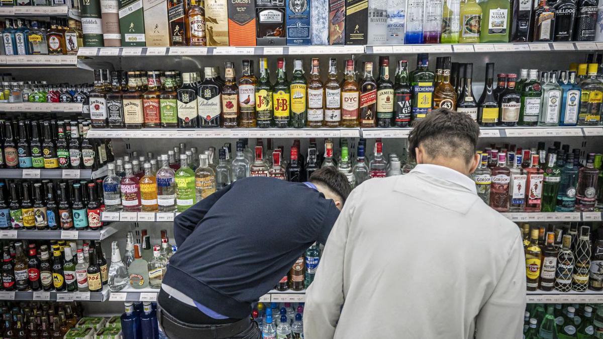 Uns joves compren alcohol en un supermercat dels voltants de plaça de Catalunya, a Barcelona. | MANU MITRU