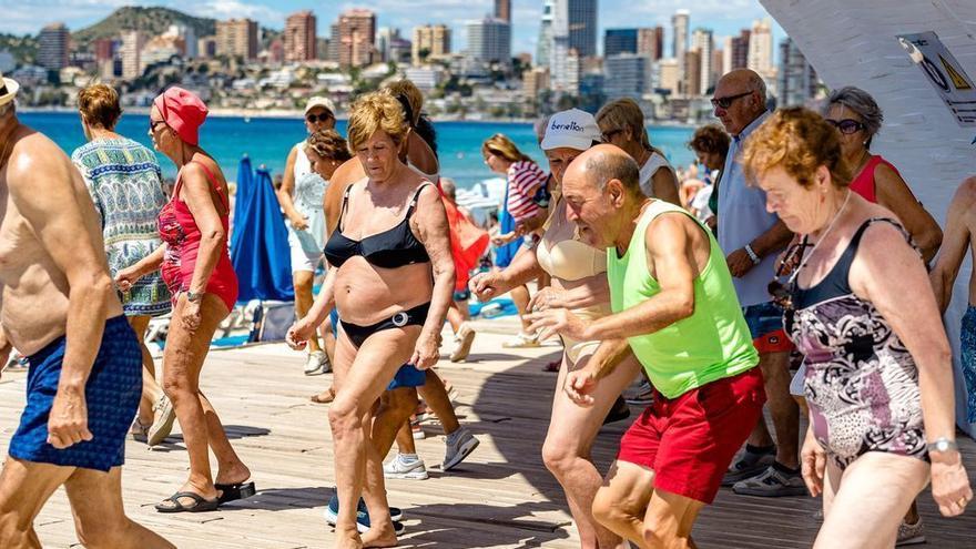 Turistas del Imserso bailando en una playa de Benidorm.