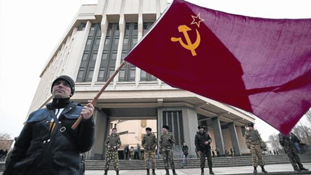 Un hombre lleva una bandera de la URSS en una marcha prorrusa en Simferópol, ayer.