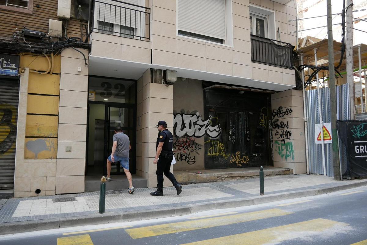 Un vecino afectado entra en el portal acompañado de un agente de policía