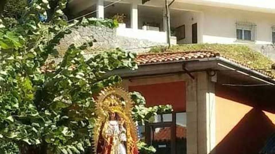 A la izquierda, la Virgen de La Salud a hombros de los mozos; sobre estas líneas, un detalle de los ramos y varias aldeanas en la procesión.