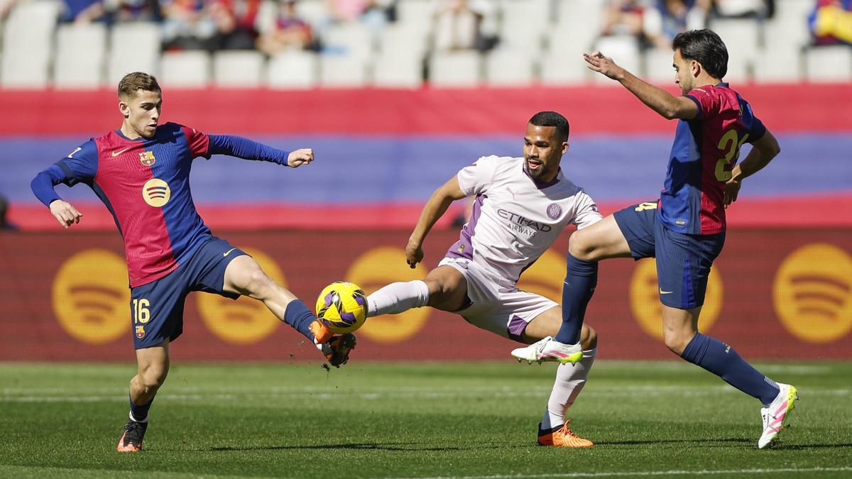 Fermín y Eric García pelean por un balón con Yangel Herrera en el Barça-Girona de Montjuïc.