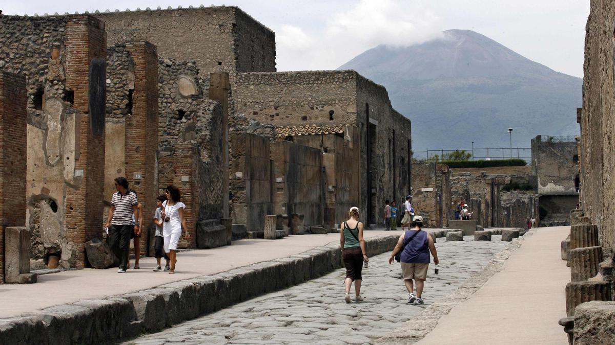 Visitantes en las ruinas de Pompeya, con el Vesubio al fondo.