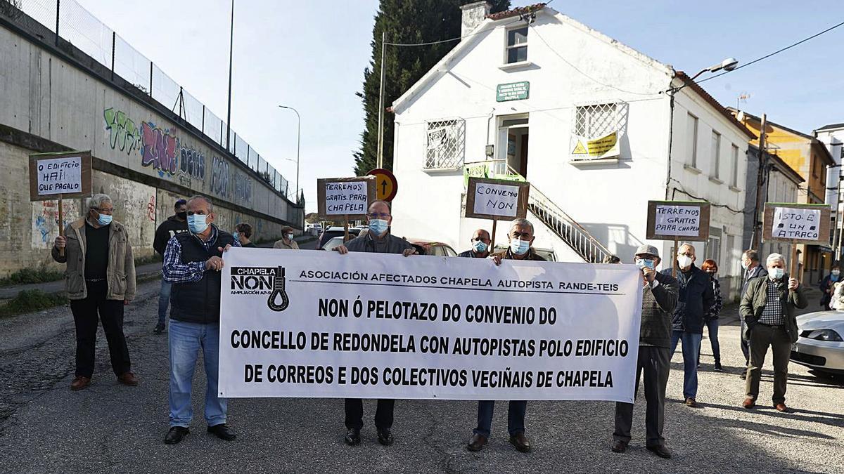 El colectivo de afectados por la AP-9, ayer, concentrados ante el edificio de Correos de Chapela.   | // R. GROBAS