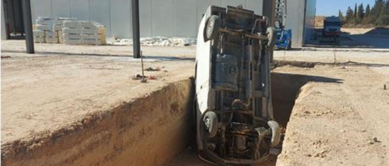 El vehículo volcado en la zanja junto a una nave en construcción del polígono industrial de Agost.