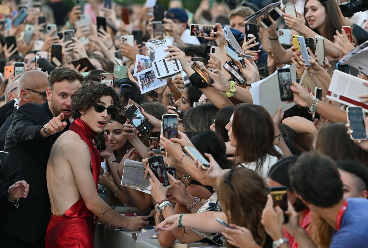 El actor estadounidense Timothee Chalamet (L) firma autógrafos a su llegada al estreno de 'Bones and All' durante el 79º Festival Internacional de Cine de Venecia, en Venecia.