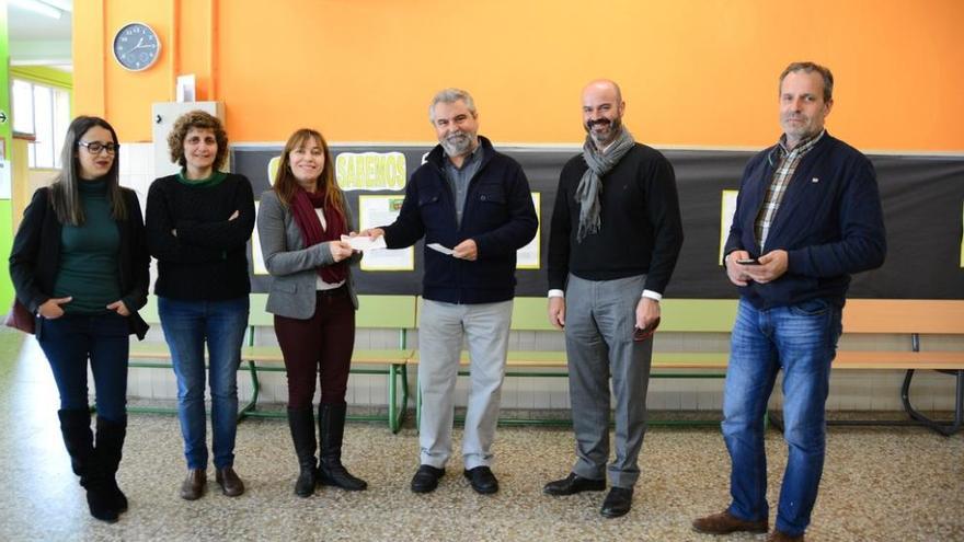 Jesús Portela(centro) entrega los cheques a la directora del colegio en presencia del alcalde, a su derecha. Gonzalo Núñez