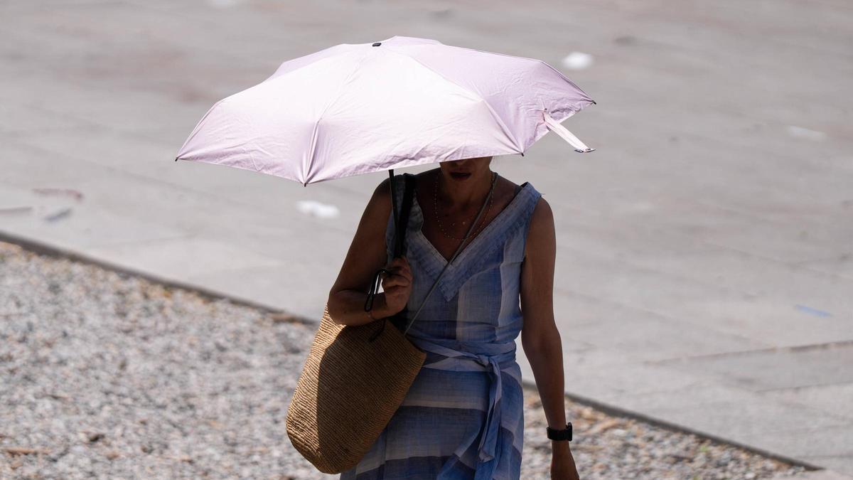 Una persona camita sota un paraigua enmig d'un episodi de calor