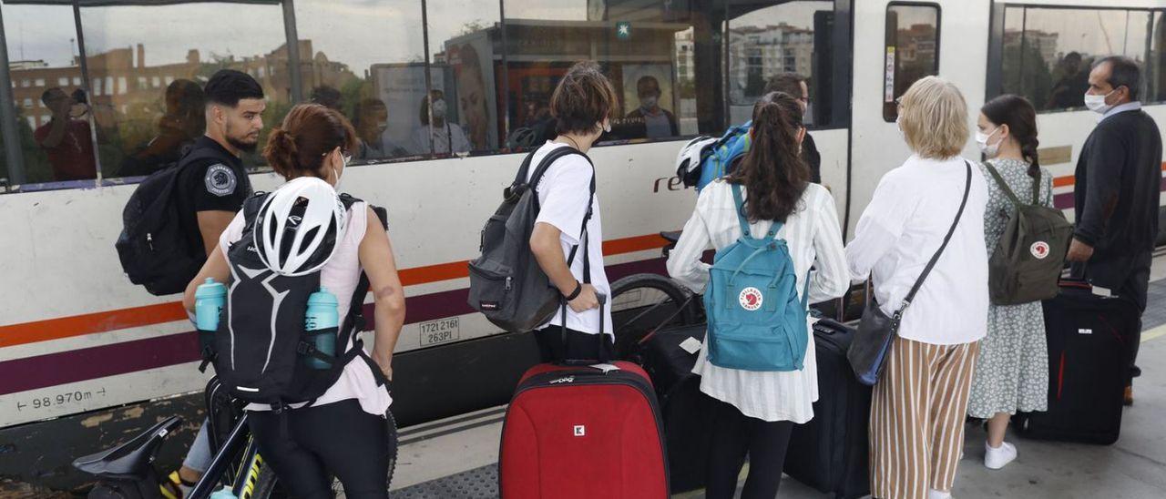 Passatgers pujant a un tren de Girona, ahir al migdia