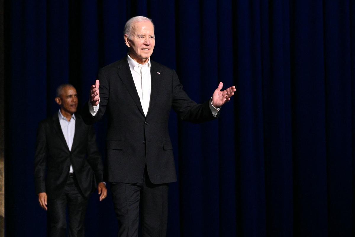 US President Joe Biden (R) gestures as he arrives onstage with former US President Barack Obama during a campaign fundraiser at the Peacock Theater in Los Angeles on June 15, 2024. (Photo by Mandel NGAN / AFP)