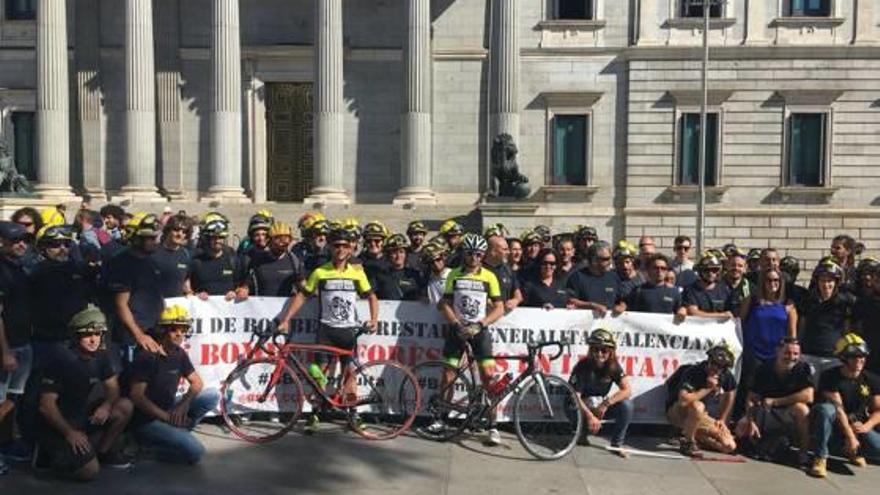 Los bomberos forestales, con los ciclistas al frente, ante el Congreso de Diputados.