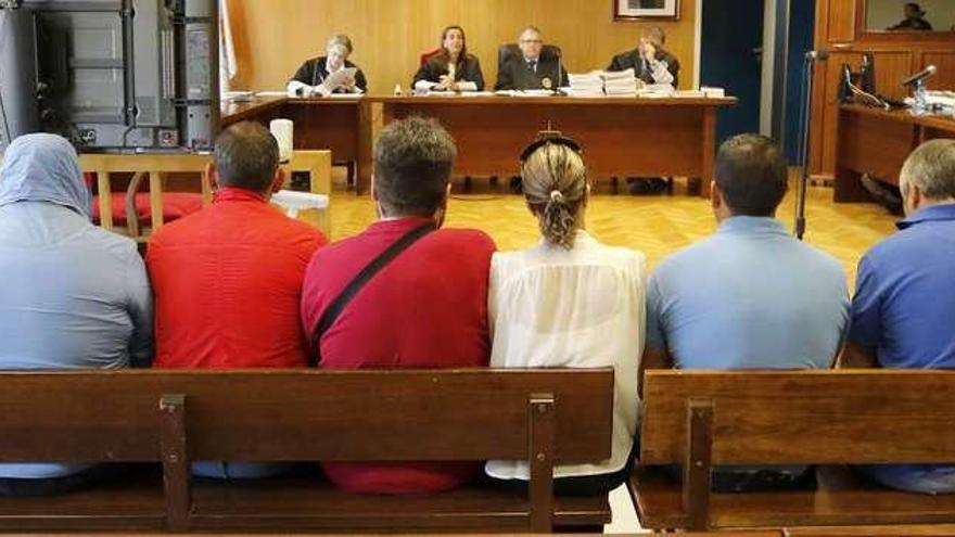 Los ocho acusados, ayer, en el banquillo de la Audiencia viguesa. // Alba Villar