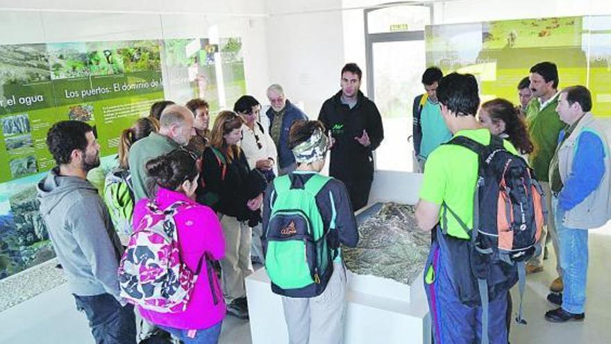 El grupo de excursionistas atiende las explicaciones del guía antes de comenzar la ruta, ayer, en Gobiendes.