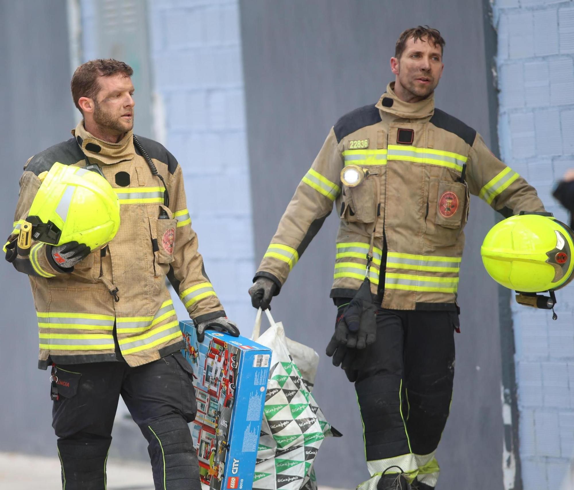 Dos bomberos recuperan un juego de Lego de un parque de bomberos de una vivienda del edificio incendiado de Campanar.