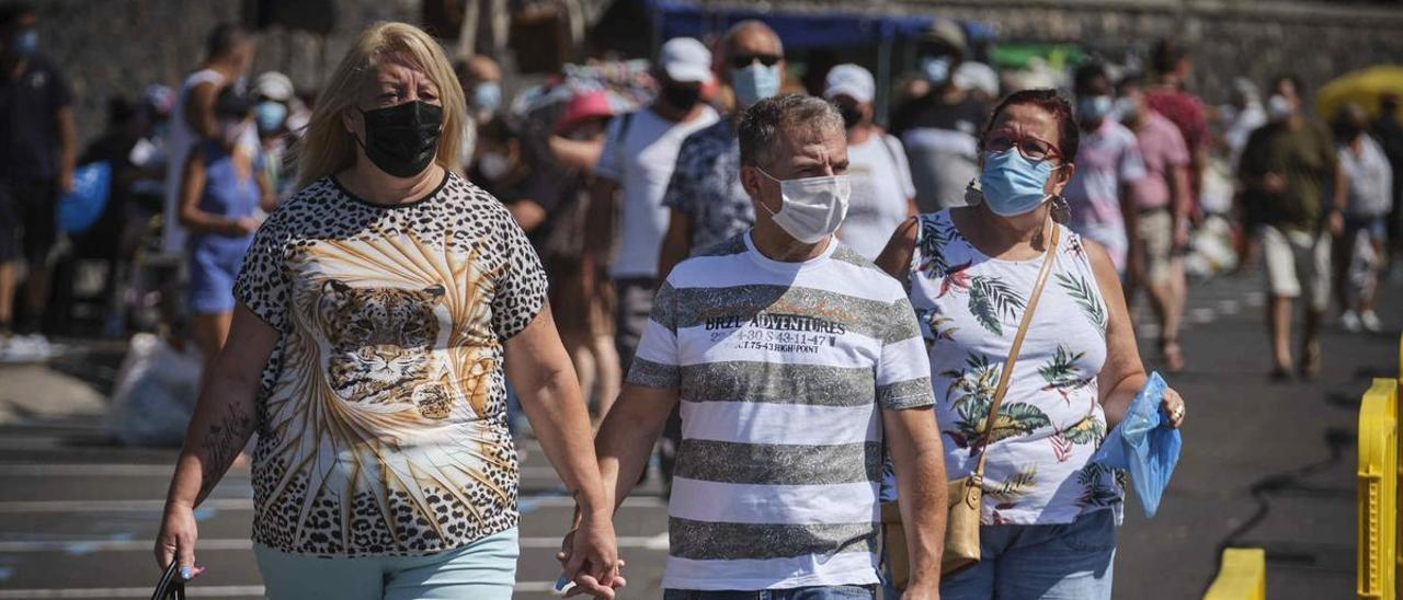 Una pareja pasea por el Rastro de Santa Cruz.