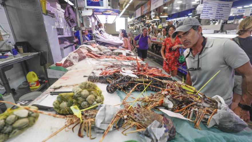 Imagen de un hombre observando los precios del pescado en el Mercat del Olivar. | MANU MIELNIEZUK