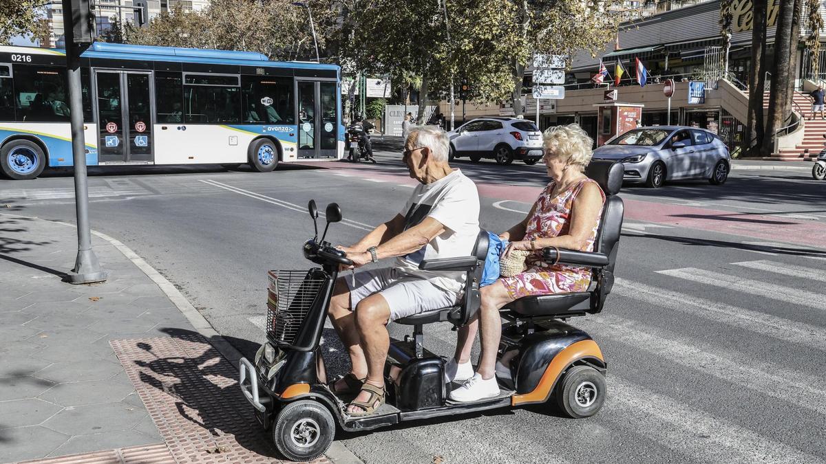 Dos turistas británicos en un "scooter" eléctrico por Benidorm.