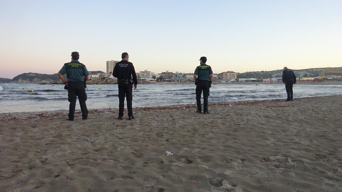 Los agentes de la Policía Local de Xàbia y la Guardia Civil comprobando el vertido en la playa del Arenal