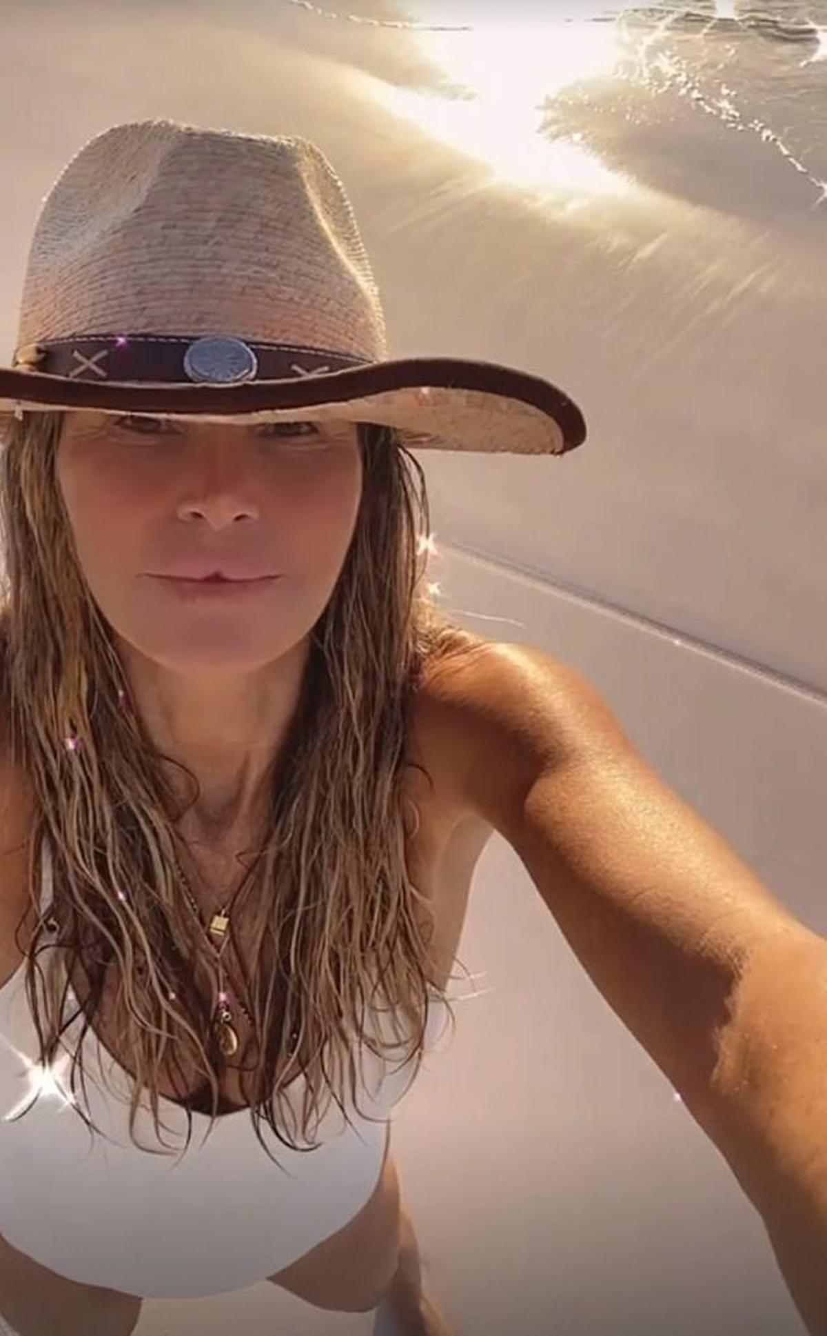 Elle Macpherson con bañador blanco en la playa