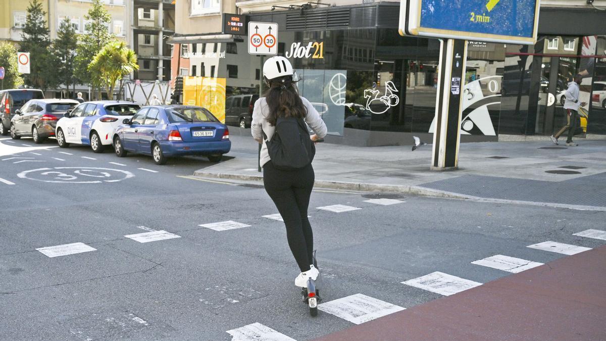 Usuaria de patinete con casco en A Coruña.